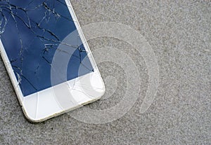 Close up modern mobile phone with broken screen on asphalt road photo