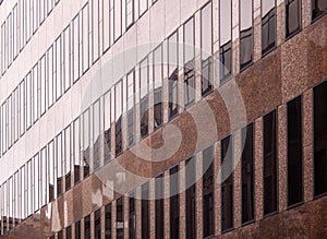 Close up of a modern office building with glass windows and reflections