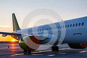 Close-up of the modern passenger airplane fuselage at sunset