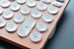 close up modern peach colour pastel calculator and white button on blue background