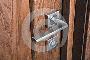 Close-up of modern steel door handle with lock