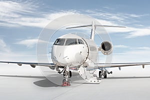 Close-up modern white business jet with an opened gangway door isolated on bright background with sky