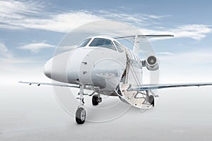 Close-up of the modern white corporate aircraft with an opened gangway door isolated on bright background with sky