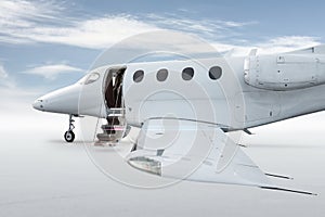 Close-up of the modern white private jet with an opened gangway door isolated on bright background with sky
