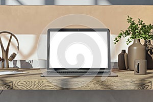 Close up of wooden designer desk top with empty white mock up place on laptop screen, coffee cup, supplies and other items