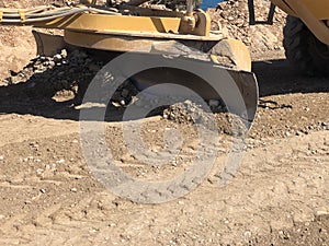 Close-up of moldboard planning road surface. Blade of motor grader during road construction works