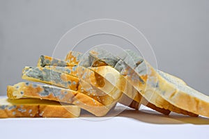 Close up of moldy bread on white background, expired can not eat any more because it is harmful to health