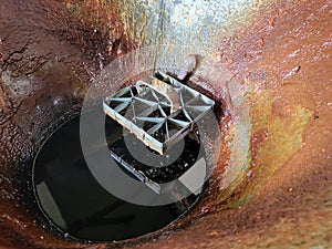 Close up of molten wax, copper and zinc block inside heated cauldron for batik stamping process. photo