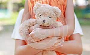 Close-up mom hands cuddle daughter and hugging teddy bear doll. Mother and child with love and relationship concept