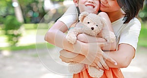 Close-up mom hands cuddle daughter and hugging teddy bear doll. Mother and child with love and relationship concept