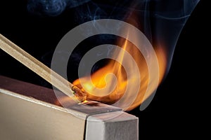 Close-up of the moment when the match ignites when moving along the box