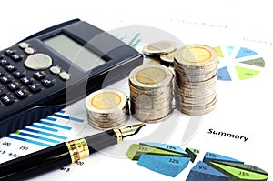 Close up of money coin stack with fountain pen and calculator on document chart for business finance concept