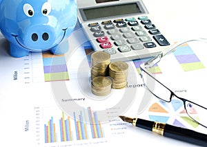 Close up of money coins stack select focus with eyeglasses and foutain pen and piggy bank and calculator