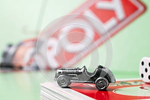 Close up of monopoly car, monopoly board and dices on the monopoly chance cards