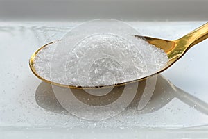 Close up of monosodium glutamate on a spoon on white background.