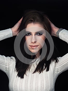 Close up mood portrait of young beautiful woman with gorgeous long brunette hair showing trendy facial makeup blue glossy eyelids