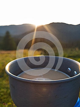 Close-up of morning coffee with milk in a hiking cup