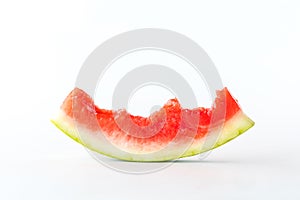 Close up of a mostly eaten watermelon slice isolated against a white background.