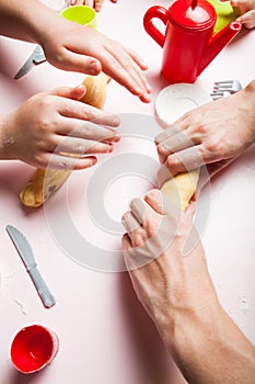 Close up, mother and child daughter preparing the dough, bake cookies. Child`s hands baking Christmas gingerbread cookies