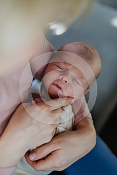 Close-up of mother cuddling with her newborn baby in their bad.