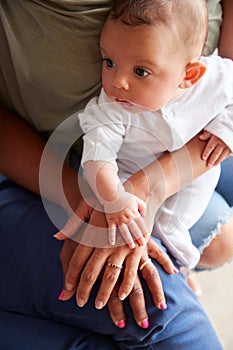 Close Up Of Mother With Daughter And Baby Granddaughter From Multi-Generation Family Holding Hands