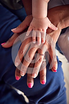 Close Up Of Mother With Daughter And Baby Granddaughter From Multi-Generation Family Holding Hands