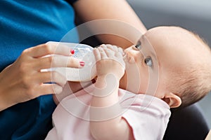 Close up of mother feeding baby with milk formula