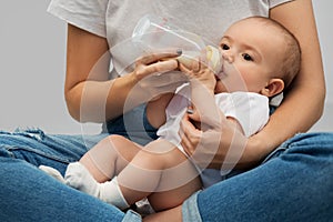 Close up of mother feeding baby with milk formula