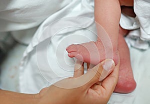 Close up mother hand holding newborn baby feet
