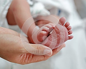 Close up mother hand holding newborn baby feet