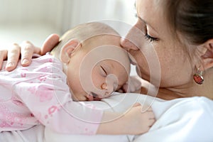 Close up of mother holding her cute baby daughter