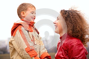 Close-up mother and son look on each other outdoo