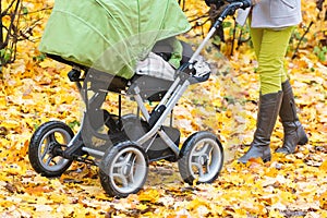 Close-up of mother strolling a pushchair with a sleeping baby