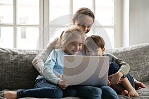 Close up mother and two kids having fun with laptop