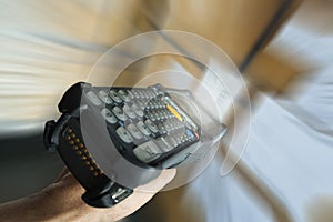 Close-up, Motion blur of worker scanning bar code scanner with package boxes.