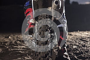 Close up of motocross wheel on the background of the track while driver sitting on the bike