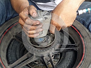 Close up of a motorcycle mechanic hands using a pneumatic gun