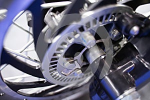 Close-up of motorcycle wheel components, metal sprockets, motorcycle shock absorbers