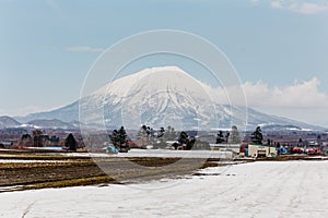 Close up Mount Yotei inactive stratovolcano with village and snow cover on the ground in winter in Hokkaido, Japan