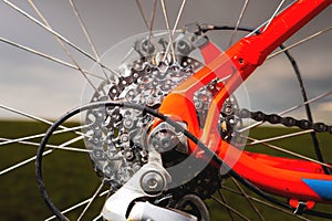 Close-up of mountain bike sprockets and chain. Bicycle parts, fragment of rear wheel brake disc, frame