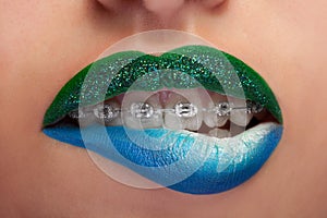 Close up mouth blue and green lips with glitter brackets