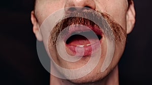 Close-up of the mouth of man who sings a song and speaks to the camera