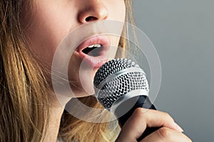 Close-up of a mouth of a woman singing into a microphone
