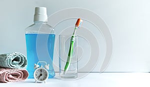 Close-up of mouthwash toothbrush and towels in bathroom morning hygiene routine dental healthcare educational concept