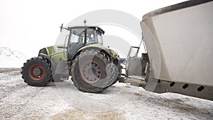 Close up for moving tractor with trailer at the farm in winter, agriculture concept. Footage. Agricultural machinery