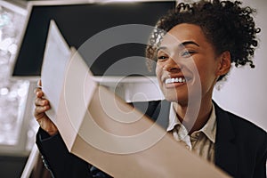 Close up mulatta woman opening envelope with letter