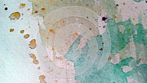 Close-up of multi-colored watercolor stains on paper. Yellow, green, blue, brown blots, drips, drops.