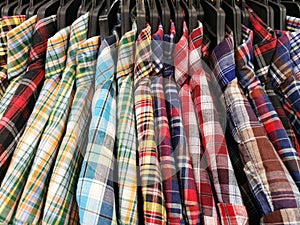 Close up Multicolor Grid pattern Shirts are hanging on Clothes Hanger