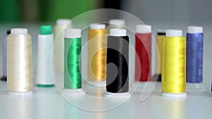 Close-up on multicolored spools of sewing thread on a white background