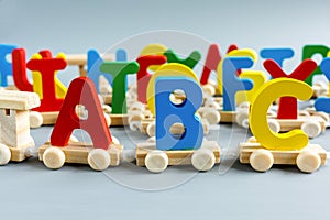 Close up Multicolored wooden letters with ABC on gray background. Set of toys for studying alphabet. Education, back to school